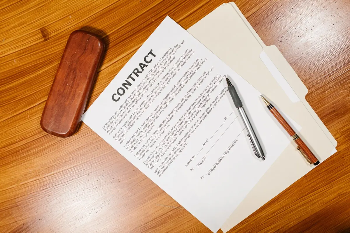 Sample employment contract on a desk with pens, showing why written terms need careful review